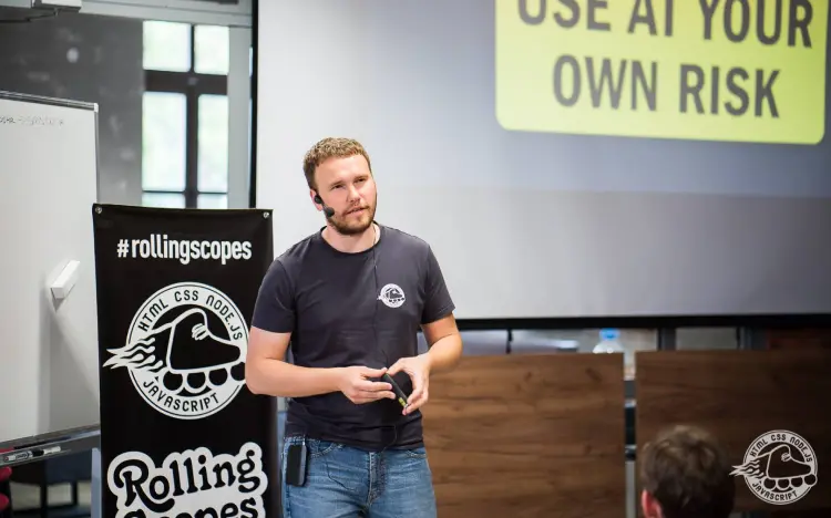 Dzmitry Varabei gives a talk in front of a screen displaying 'USE AT YOUR OWN RISK' message